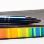 Pen resting on a notebook with multicoloured pages
