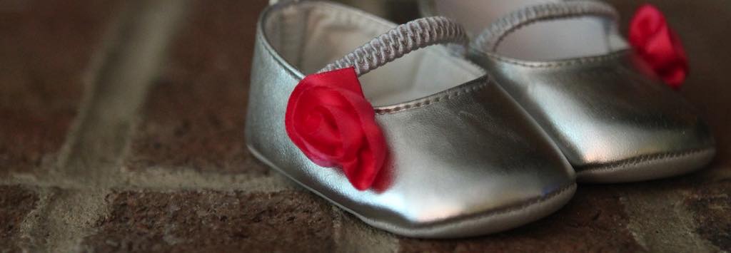A pair of silver and red baby shoes