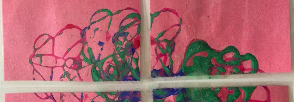 Cropped puzzle painting: green, blue and pink swirls on pink paper